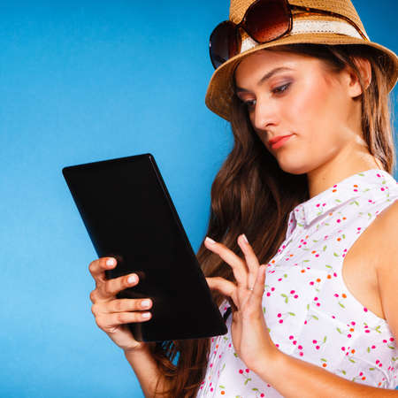 Technology internet modern lifestyle concept. Young summer girl using tablet computer reading. Latin female with e-book reader touchpad pc.の写真素材