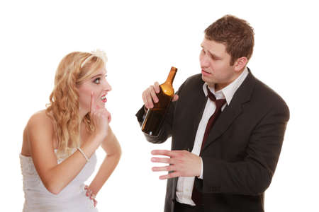 Wedding couple, unhappy bride with alcoholic drinking groom. Woman looking her future - violence alcoholism problems conceptの写真素材