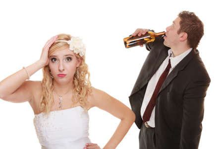 Wedding couple, unhappy bride with alcoholic drinking groom. Woman looking her future make decision - violence alcoholism problems conceptの写真素材