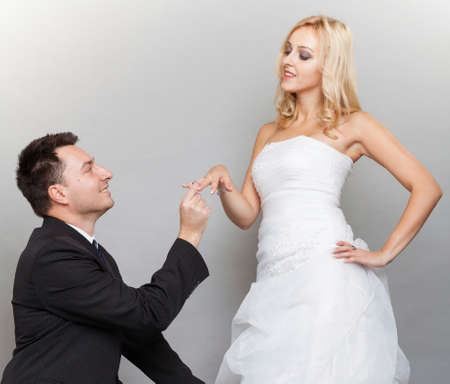 Wedding day. Groom putting a wedding ring on brideの写真素材