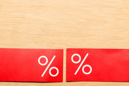 Shopping and sale concept. Red price labels with percent sign on wooden surface background....
