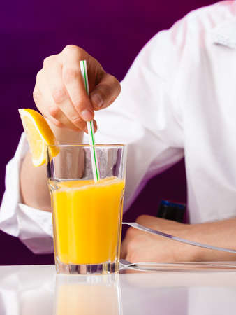 Young stylish man bartender preparing serving alcohol cocktail drink  over bar counterの写真素材