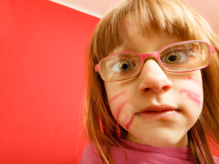 Childhood and development concept. Little girl schoolchild in glasses with the body painted as e cat, funny face. Wide angle viewの写真素材