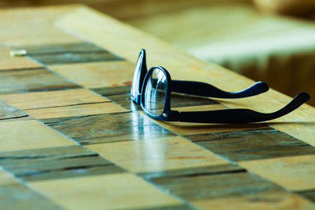 Eyecare concept. Pair of stylish glasses on a checkered tableの写真素材
