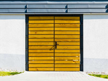 Garage, house or warehouse entry. Yellow wooden door outside.の写真素材