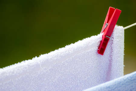 Housework. Clean wet laundry towels with clothespins hanging to dry on the line clothesline outdoor. Rural scene.の写真素材