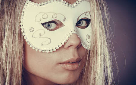 Holidays, people and celebration concept. Closeup woman face caucasian blonde girl with white carnival maskの写真素材