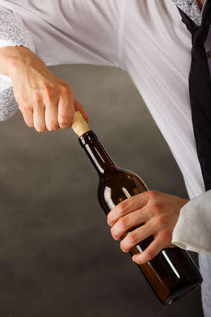 Man waiter opening bottle of wineの写真素材