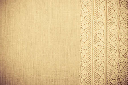 Lace ribbon on natural linen, bright cloth fabric background. Border frame. vintage styleの写真素材