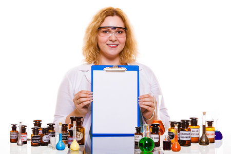 Experiment, research in progress. Chemist woman or student girl, laboratory assistant or scientific researcher with chemical glassware test flask and blank clipboardの写真素材