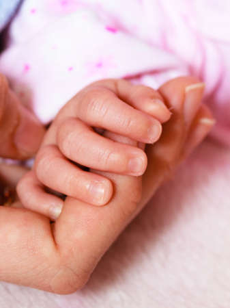Parenting and love concept. Closeup newborn baby holding his mothers fingerの写真素材