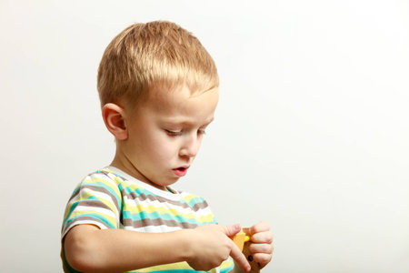 Little blond boy child kid preschooler playing with colorful building blocks toys interior. At home. Childhood and development.の写真素材