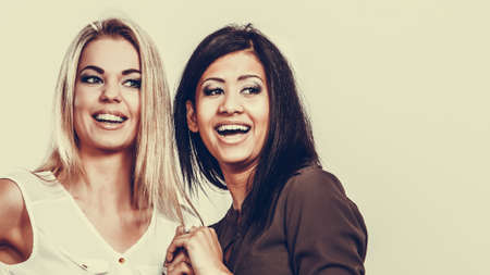 Beautiful different race women friends black and white girls having fun smiling studio shot