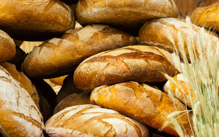 many rustic baked traditional rye bread loaves on a market stall outdoor