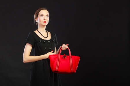Fashion beauty and elegance concept. Woman retro style. Elegant lady black dress holding red handbagの写真素材