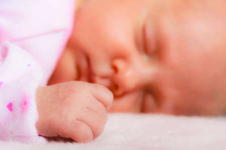 Closeup little newborn baby girl 24 days sleepingの写真素材