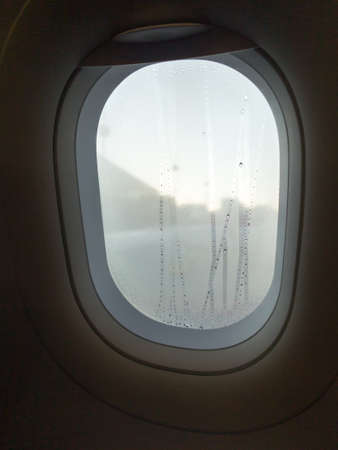 Closeup aircraft's porthole, window in cabin of airplaneの写真素材
