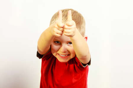 Happy childhood. Portrait of smiling funny blond boy child kid preschooler showing thumb up success...