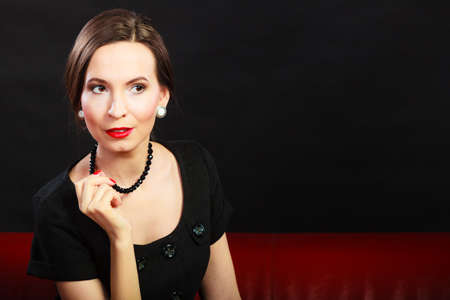 Fashion beauty and elegance concept. Woman retro style portrait. Elegant lady hair styling red lips on blackの写真素材