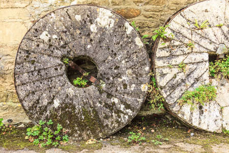 English cottage and old vintage coach stone wheels around houseの写真素材