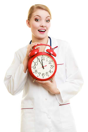 Health care medical checkup concept. Doctor with big red alarm clock reminding to do health check isolated on whiteの写真素材