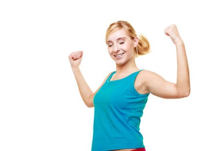 Fitness woman showing fresh energy flexing biceps muscles smiling closed eyes. Girl in sportwear...