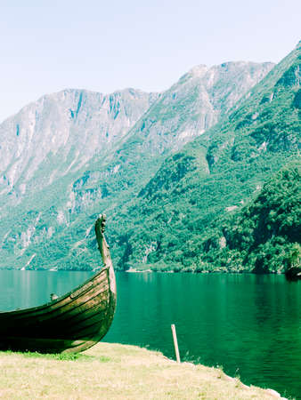 Tourism and travel. Mountains and fjord Sognefjord in Norway, Scandinavia. Old viking boat on seashore.の写真素材