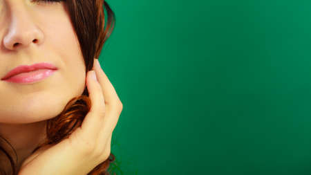 Closeup part of woman face female lips, thoughtful girl on green background with copy space text...