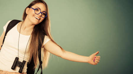 Travel vacation hitchhiking concept. Summer girl thumbing and hitch hiking filtered photo