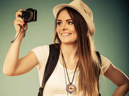 Travel and tourism active lifestyle concept. Tourist woman with backpack taking photo with camera...