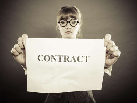 Business, documents and legal concept - serious unhappy businesswoman showing crumpled contractの写真素材