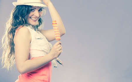 Summer vacation happiness concept. Smiling joyful and cheerful woman fashionable female model eating ice pop cross filterの写真素材