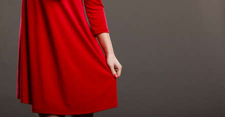 Woman part body. Dance posing girl in red dress on gray background in studio.の写真素材