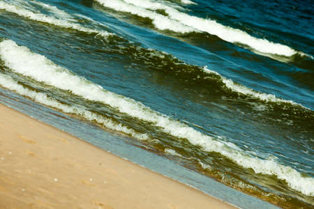 Seascape. Sea waves on the shore of the sandy beach. Summer vacation in the resort.