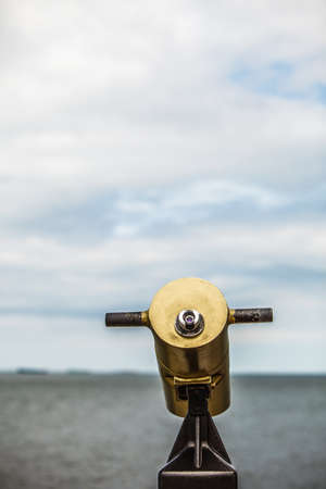 watching sea ocean trought binoculars telescope on a turistic tower. travel and tourismの写真素材