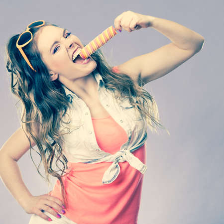 summer holidays happiness concept. happy joyful and cheerful young woman female model eating ice pop cross filterの写真素材