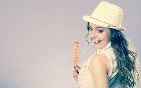 Summer vacation happiness concept. Smiling joyful and cheerful woman fashionable female model eating ice pop cross filterの写真素材