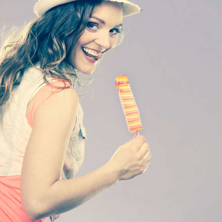 Summer vacation happiness concept. Smiling joyful and cheerful woman fashionable female model eating...