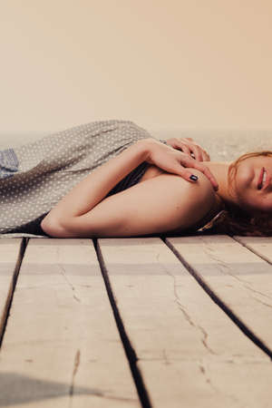 Holidays summer relaxation concept. Young woman relaxing on pier outdoorの写真素材