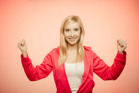 Fitness woman showing fresh energy flexing biceps muscles smiling closed eyes. Girl in sportwear energetic and funの写真素材