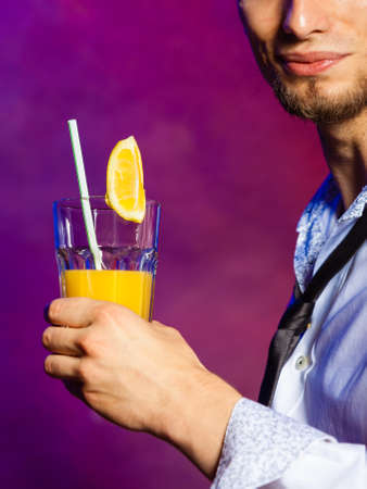 Young stylish man bartender preparing serving alcohol cocktail drinkの写真素材