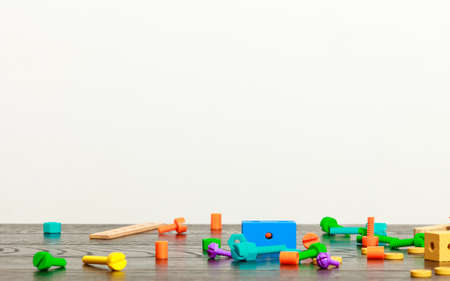 multicolored building blocks toy on wooden table empty interior white wall backgroundの写真素材