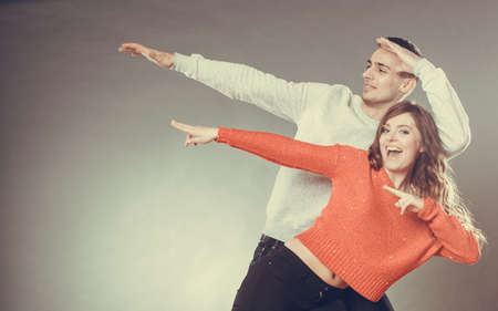 Love friendship and happiness oncept. Smiling young couple having fun, happy man and woman studio shot on grayの写真素材