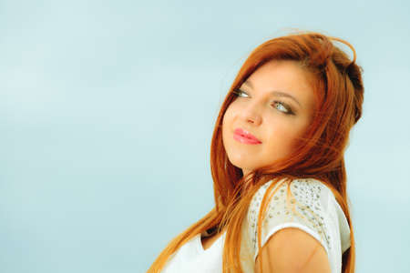 Holidays, vacation travel and freedom concept. Beautiful redhaired happy girl on beach, portraitの写真素材