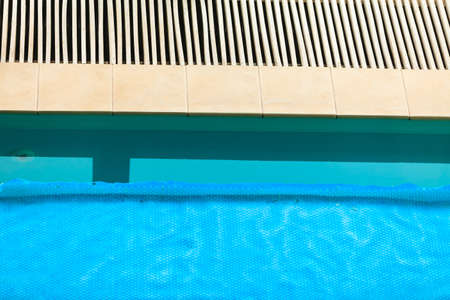 Relax active lifestyle or travel concept. Swimming pool at hotel close up, water covered with safety net gridの写真素材