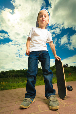Active childhood. Little man skateboarding. Skater boy child kid with his skateboard. Outdoor.の写真素材