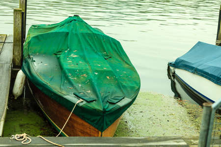 Fishing boat rowboat drifting floating on water moored at coast.