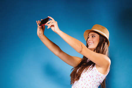 Technology internet and happy people concept - teen girl taking self picture selfie with smartphone...