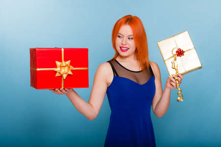 People celebrating holidays, love and happiness concept - happy red hair girl with gift boxes studio...