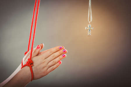 Tied hands. Human forced to pray. Fake faith belief concept. Christian religion. Praying to god because of society pressure.の写真素材